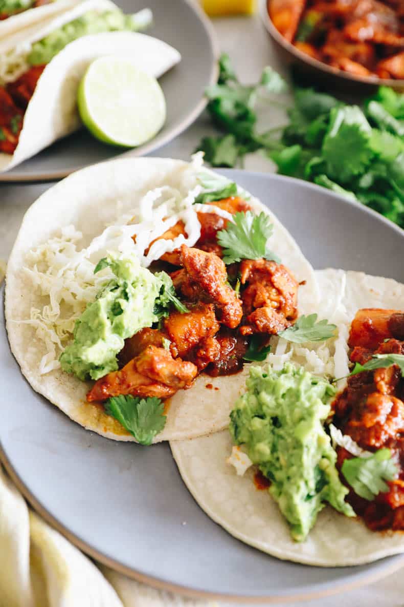 chicken al pastor with guacamole and cabbage in a taco shell.