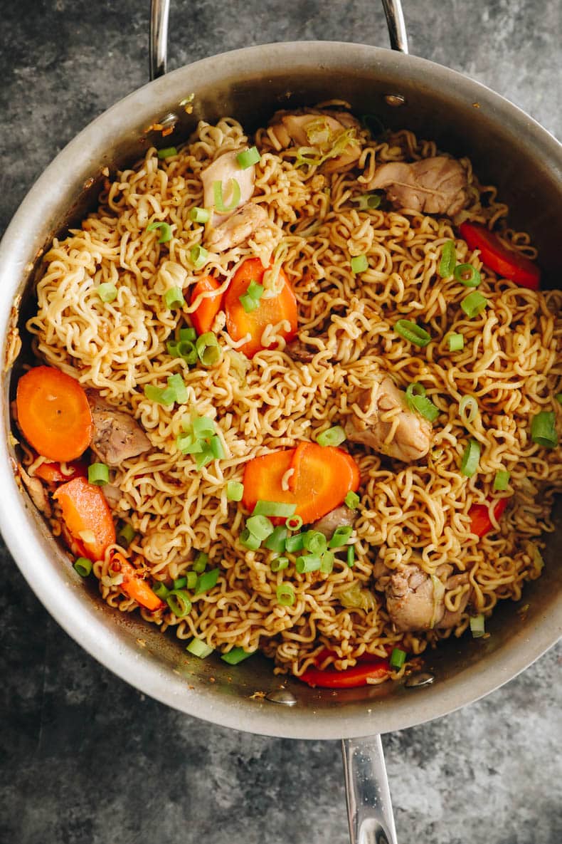 overhead image of chicken chow mein in a metal wok.