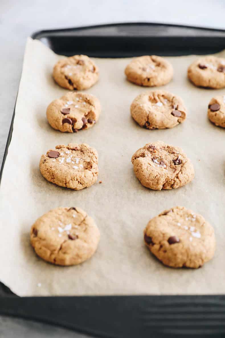 Baked protein cookies on a baking sheet with parchment paper.