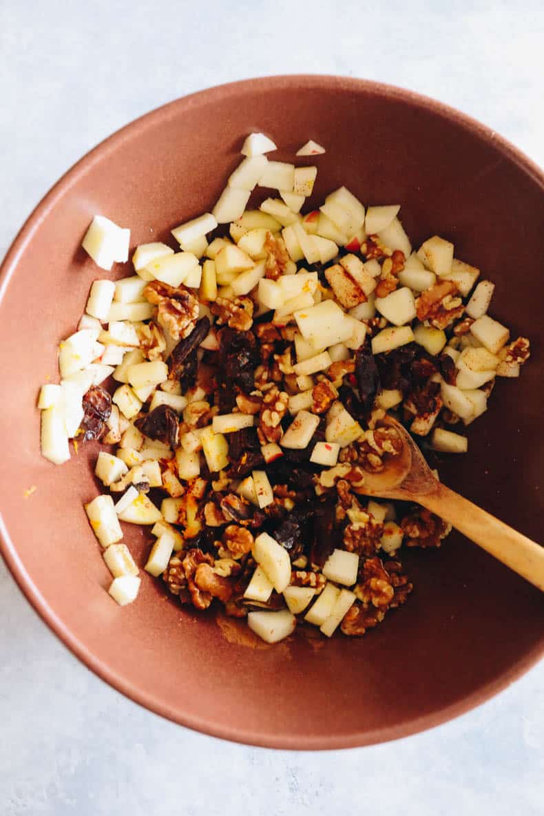 apples, dates, walnuts chopped in a large brown bowl.