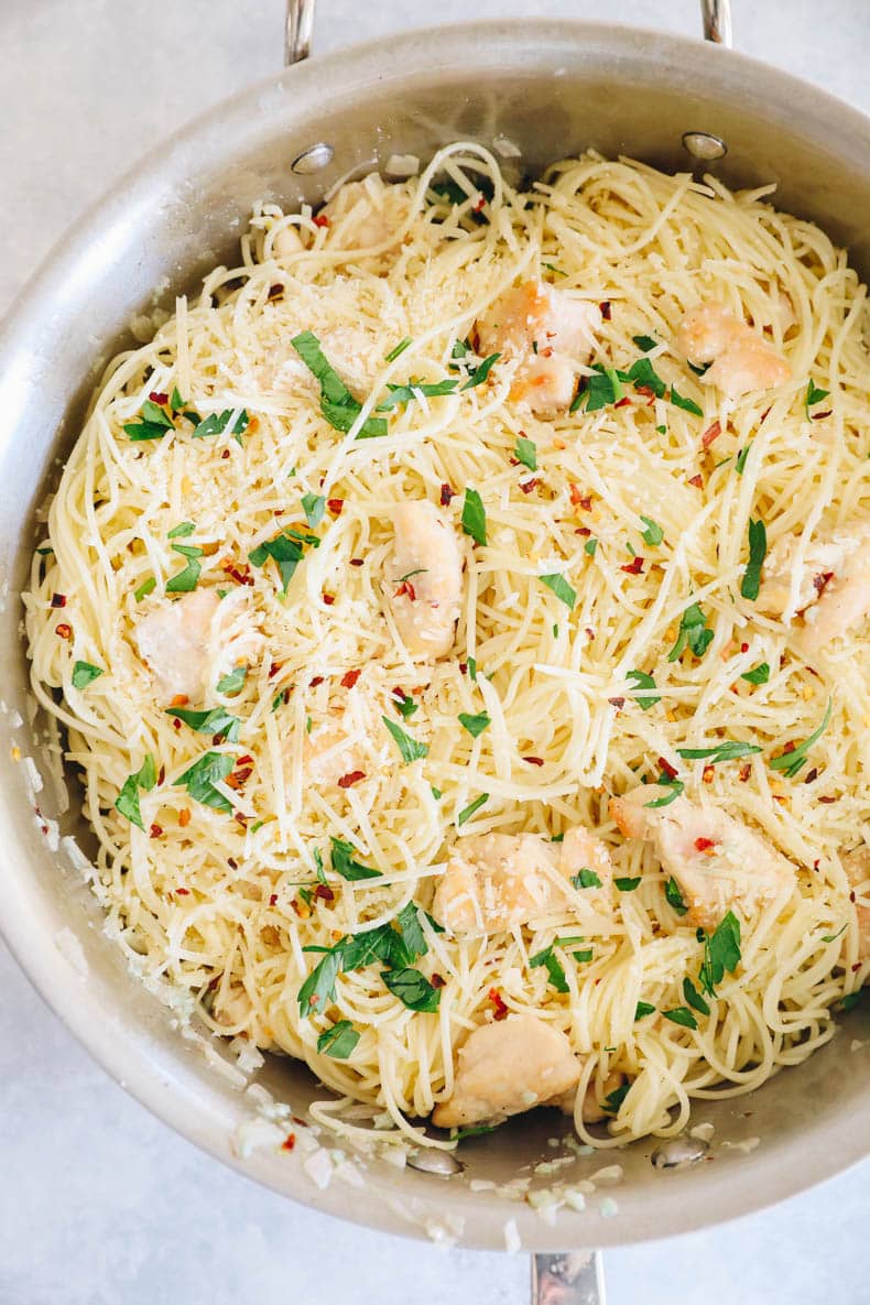 copycat olive garden chicken scampi in a large pot topped with parsley, chili flakes and parmesan.