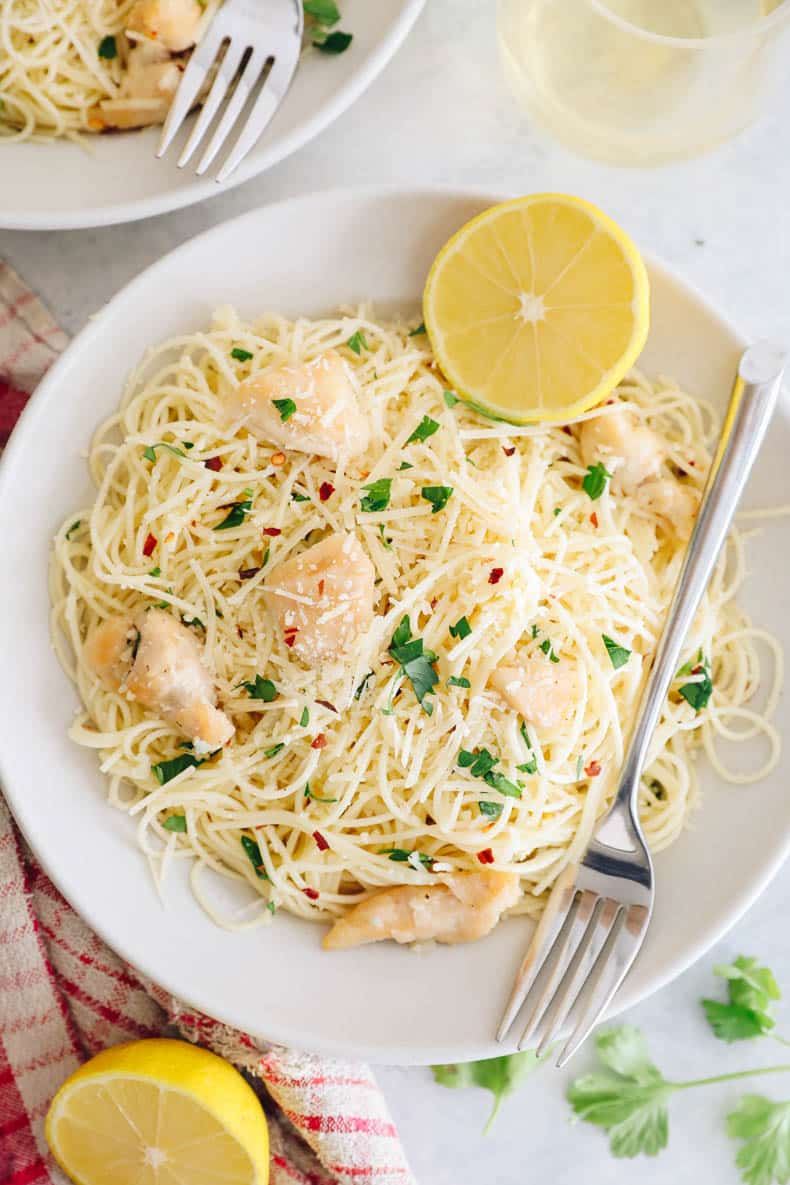 chicken scampi in a white bowl with lemon.