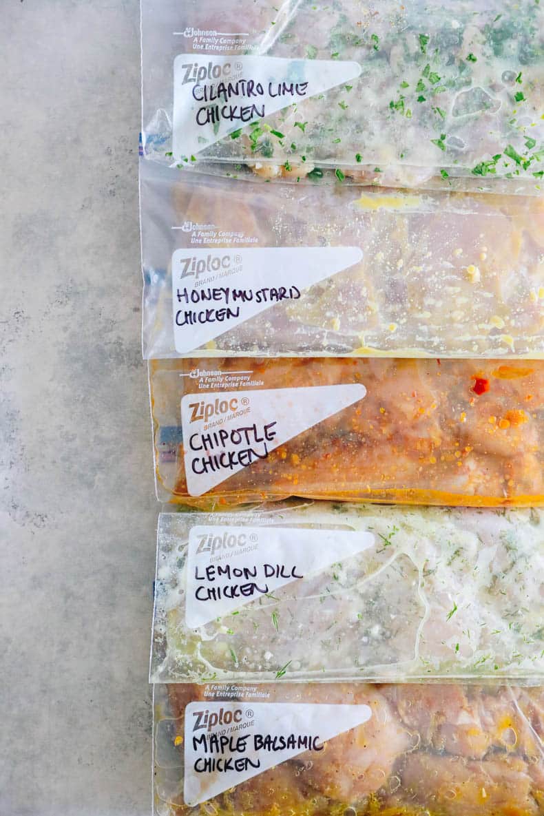 5 different chicken thigh marinade recipes marinating in ziploc bags.