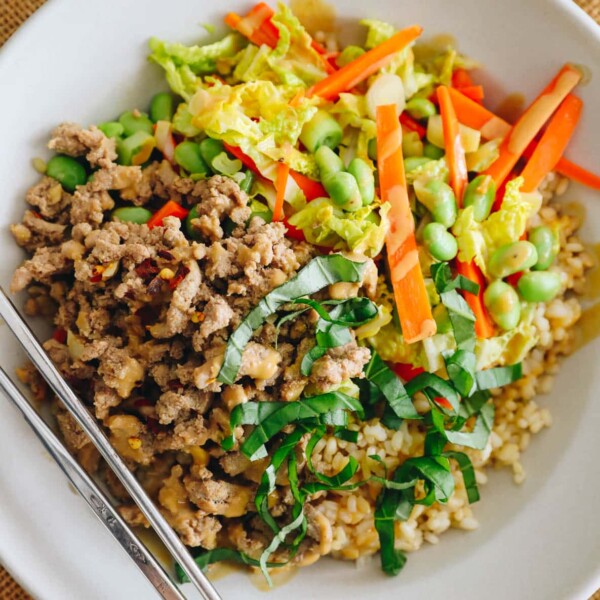 overhead of thai bowl with ground turkey, thai basil, carrots, edamame, cabbage and green onions coated with a peanut sauce.