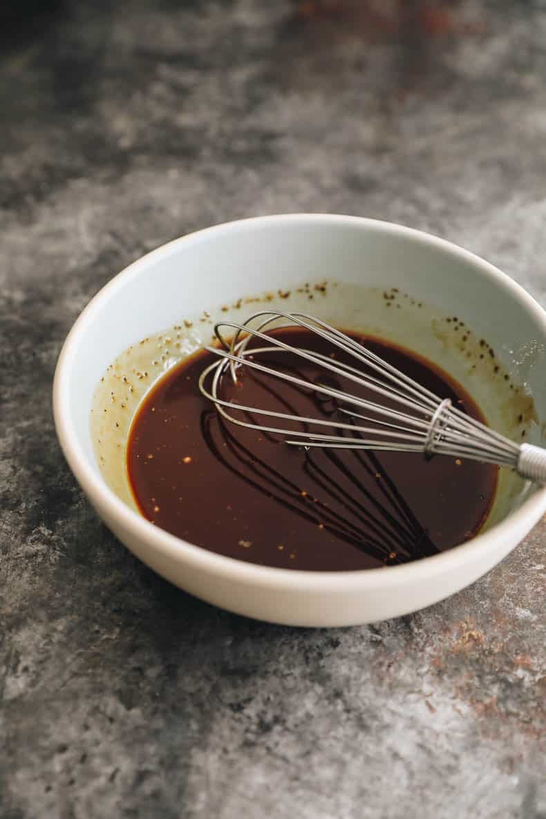 chow mein sauce ingredients in a blue and white bowl with a whisk