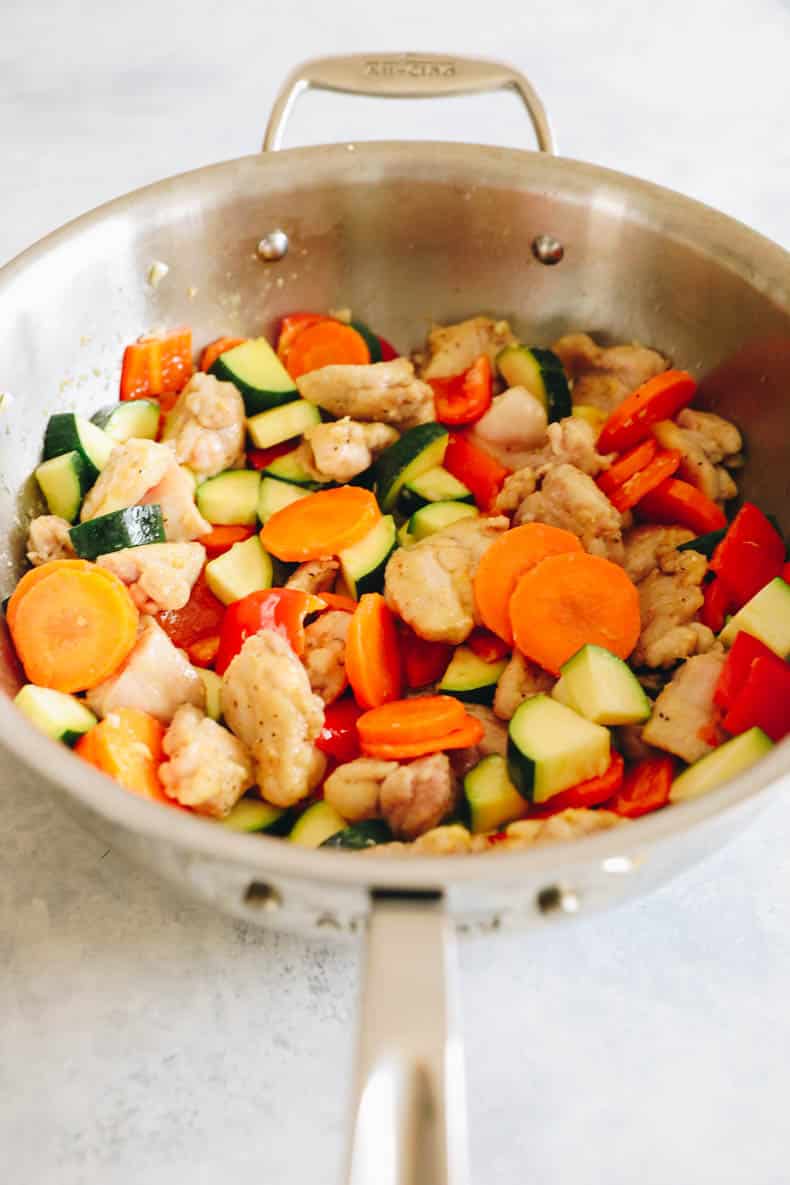 kung pao chicken and veggies in a wok.