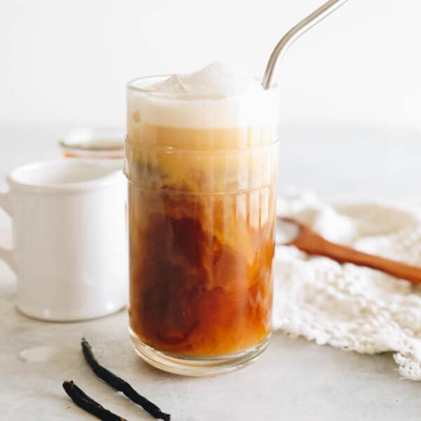 vanilla sweet cream cold brew in a clear glass with vanilla cold foam and a metal straw.